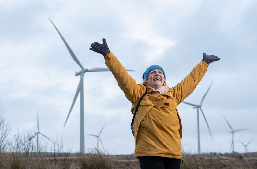 Michele celebrates in front of Whitelee Windfarm
